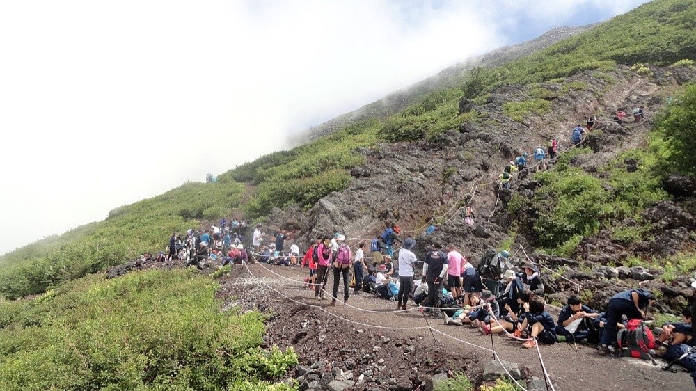 富士山の登山道。岩やザレ場が続く区間を多くの登山者が歩いている