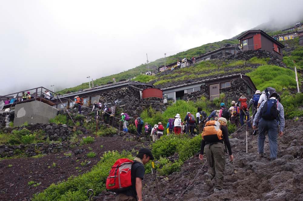 富士山の登山道を歩く登山者たち。大きなザックの人も身軽な人もいて、装備や経験はさまざま