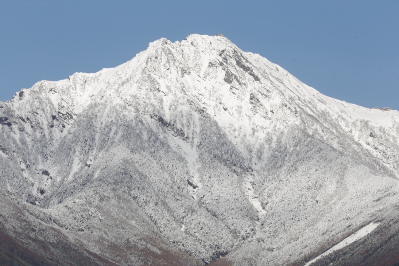 雪をまとった赤岳の山頂部。急な斜面に雪と岩肌が入り混じっている